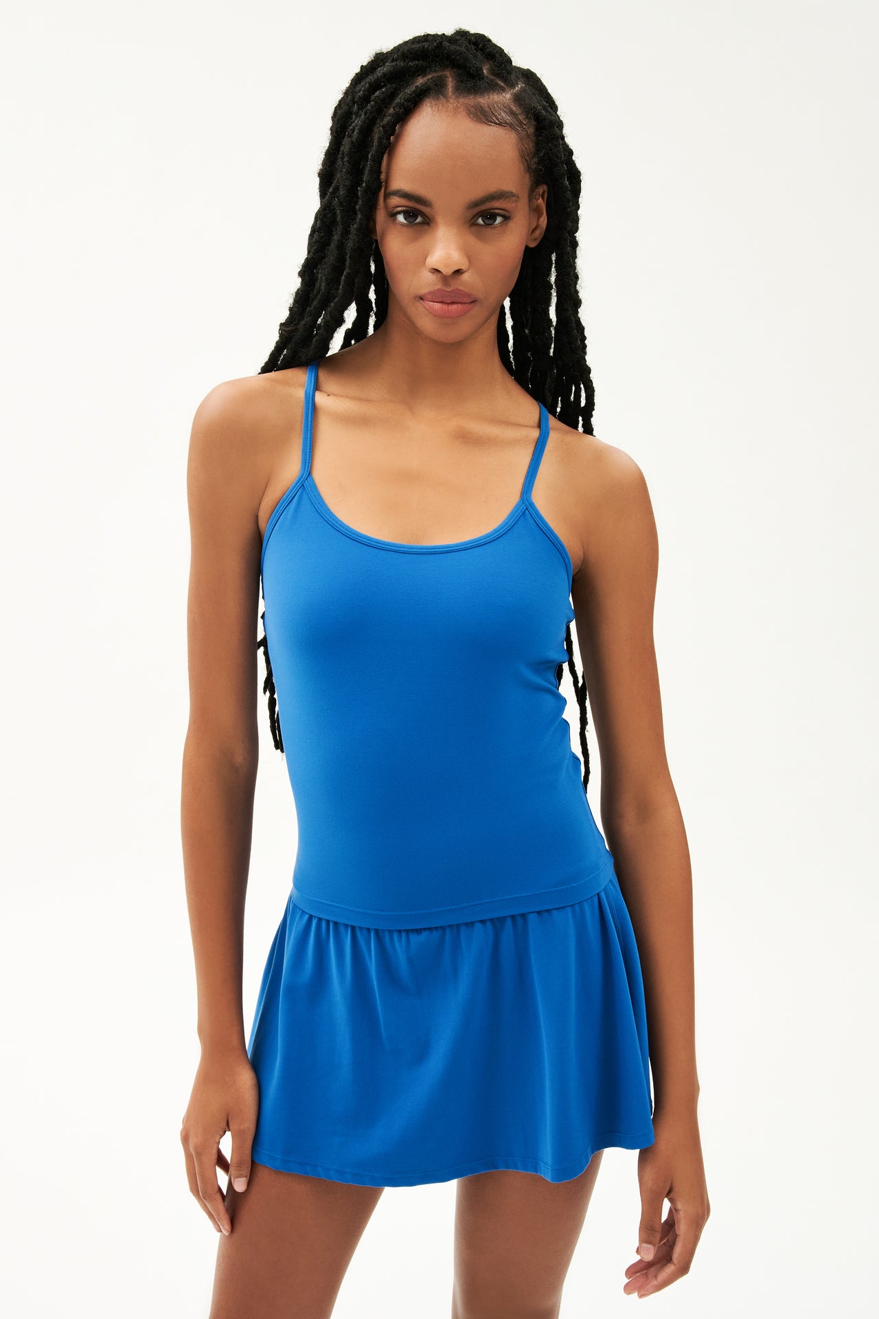 Front view of girl wearing blue spaghetti strap tank top with blue skirt