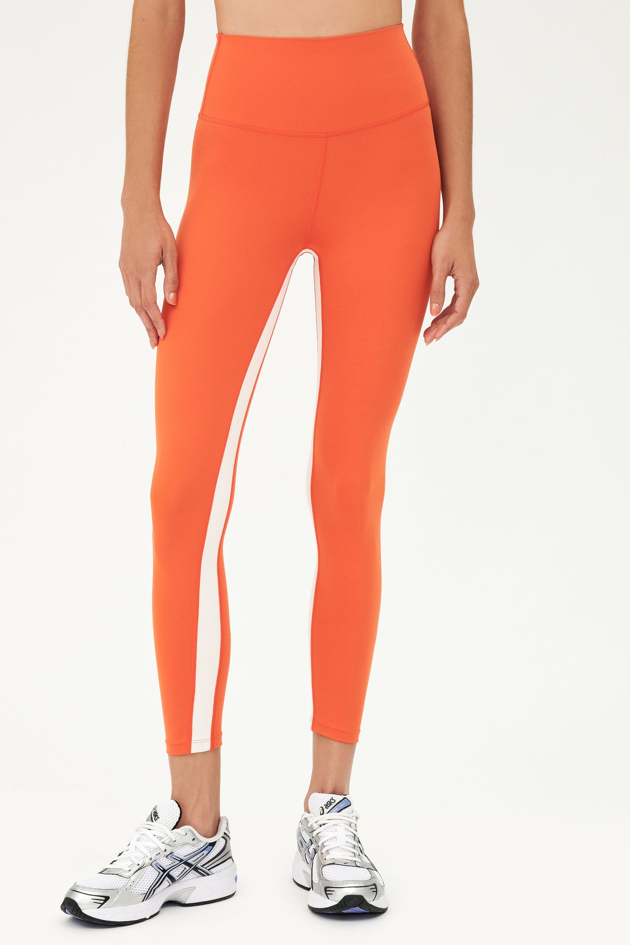 Half body, front, shot of woman in orange tights with white stripe on inseam