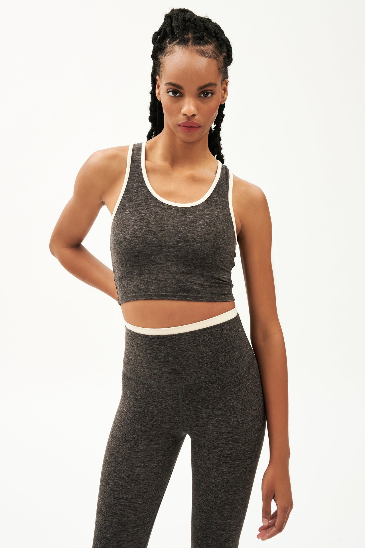 Front view of girl wearing cropped grey tank top with white trim and grey leggings with a thin white waistband