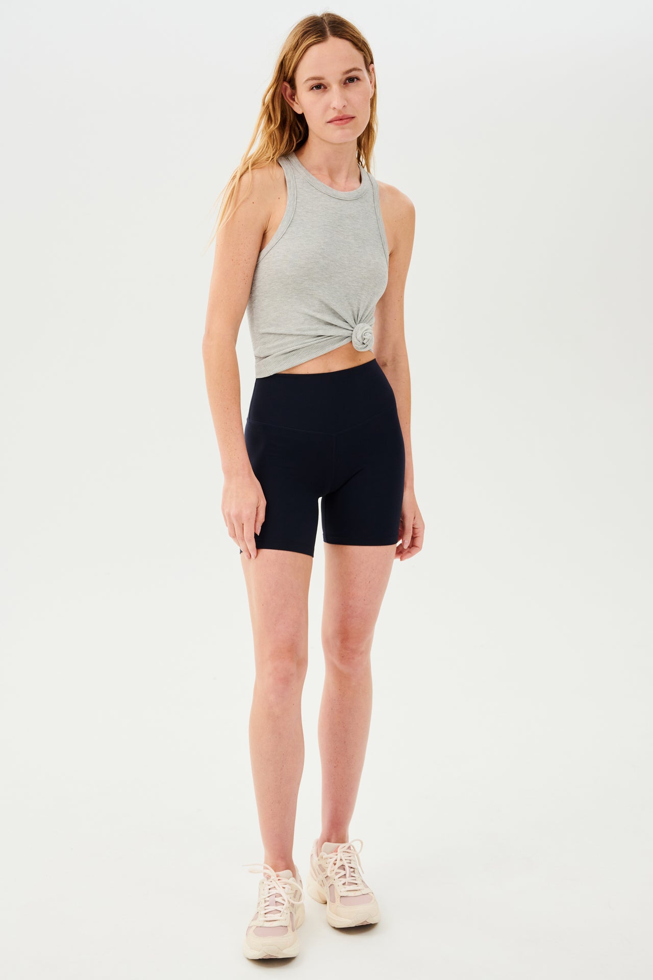 The model is wearing a SPLITS59 Kiki Rib Tank Full Length in Heather Grey and black shorts.