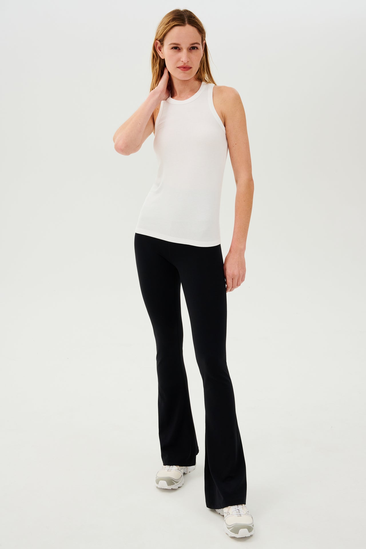 The model is wearing a SPLITS59 Kiki Rib Tank Full Length in White and black leggings, perfect for yoga or gym workouts.