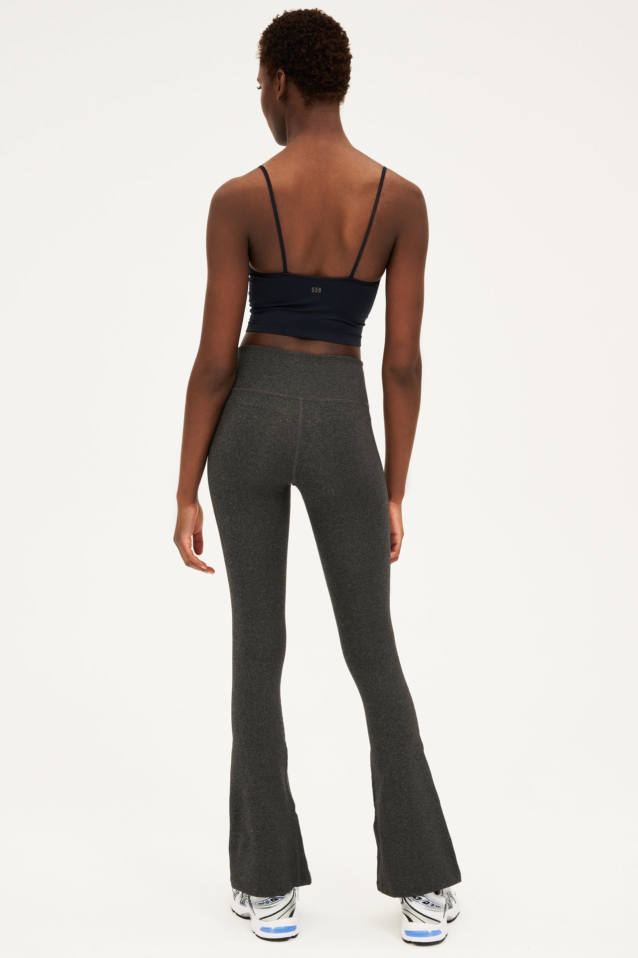 The back view of a woman wearing SPLITS59 Raquel Flared Legging in Heather Grey made from 4-way stretch fabric.