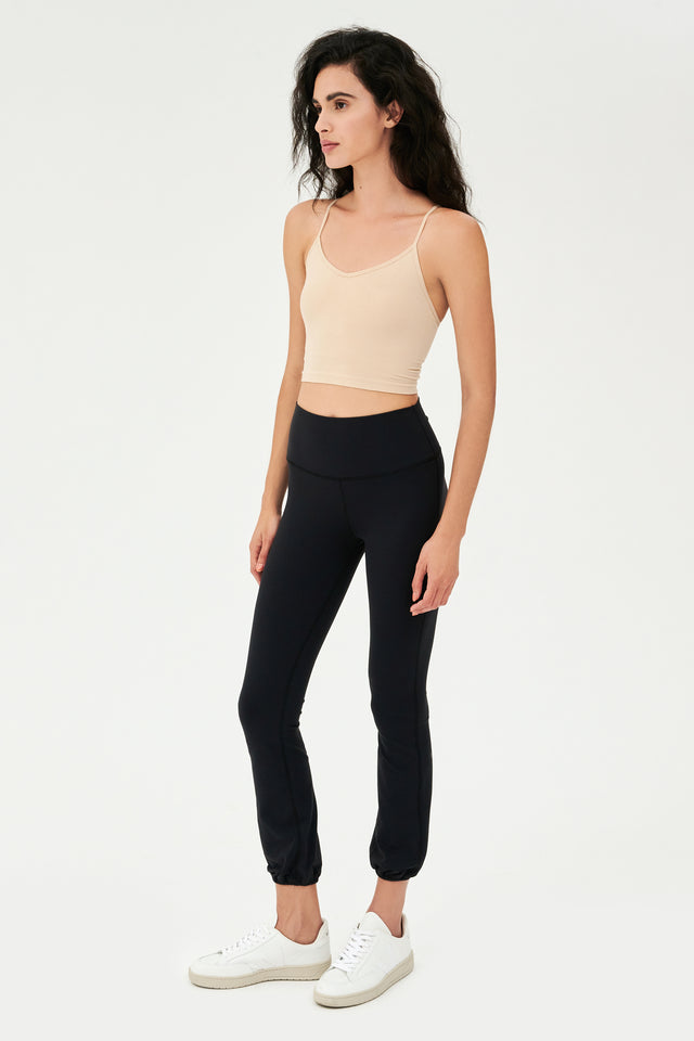 The model is wearing a black crop top and SPLITS59's Icon High Waist Supplex Legging in Black.