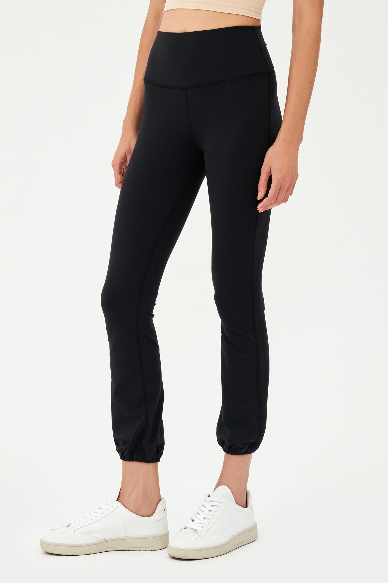 A woman wearing SPLITS59's Icon High Waist Supplex Legging in Black and a white top.