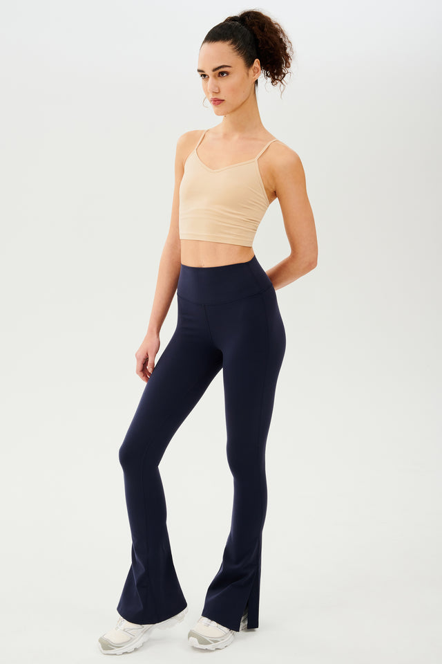 The model is wearing navy flared leggings and a beige Loren Seamless Cami - Nude with a shelf bra from Splits59.