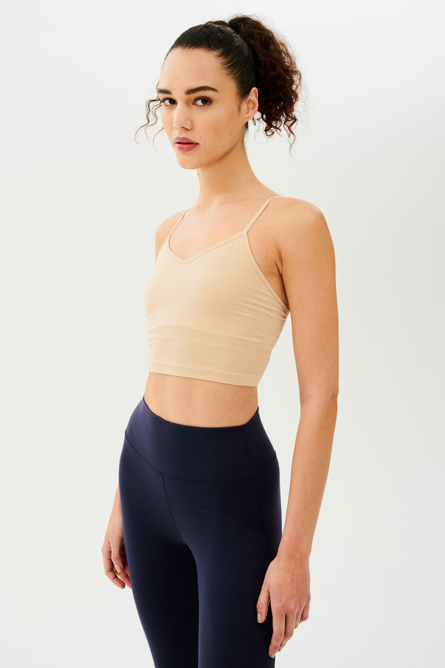 The model is wearing a Loren Seamless Cami - Nude tank with chafe-free fabric and navy leggings from Splits59.