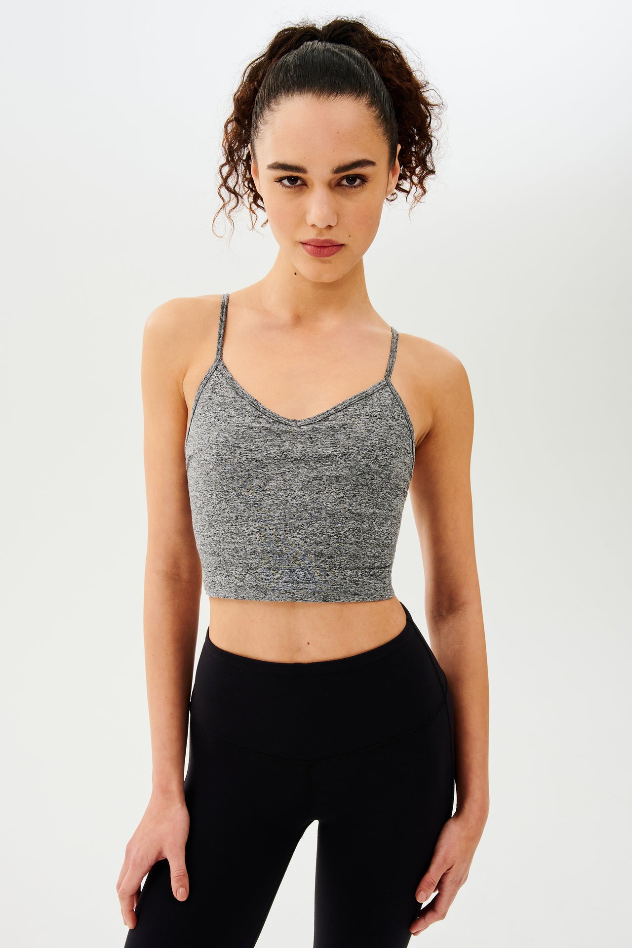 The model is wearing a Splits59 Loren Seamless Cami in Heather Grey and black leggings.