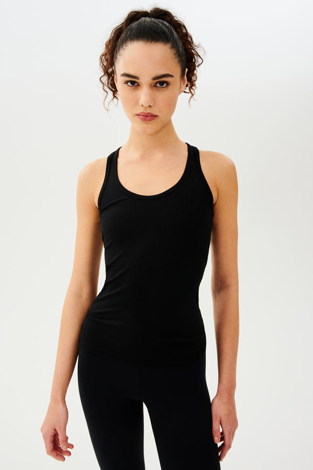 Front view of girl wearing a black tank top and black leggings