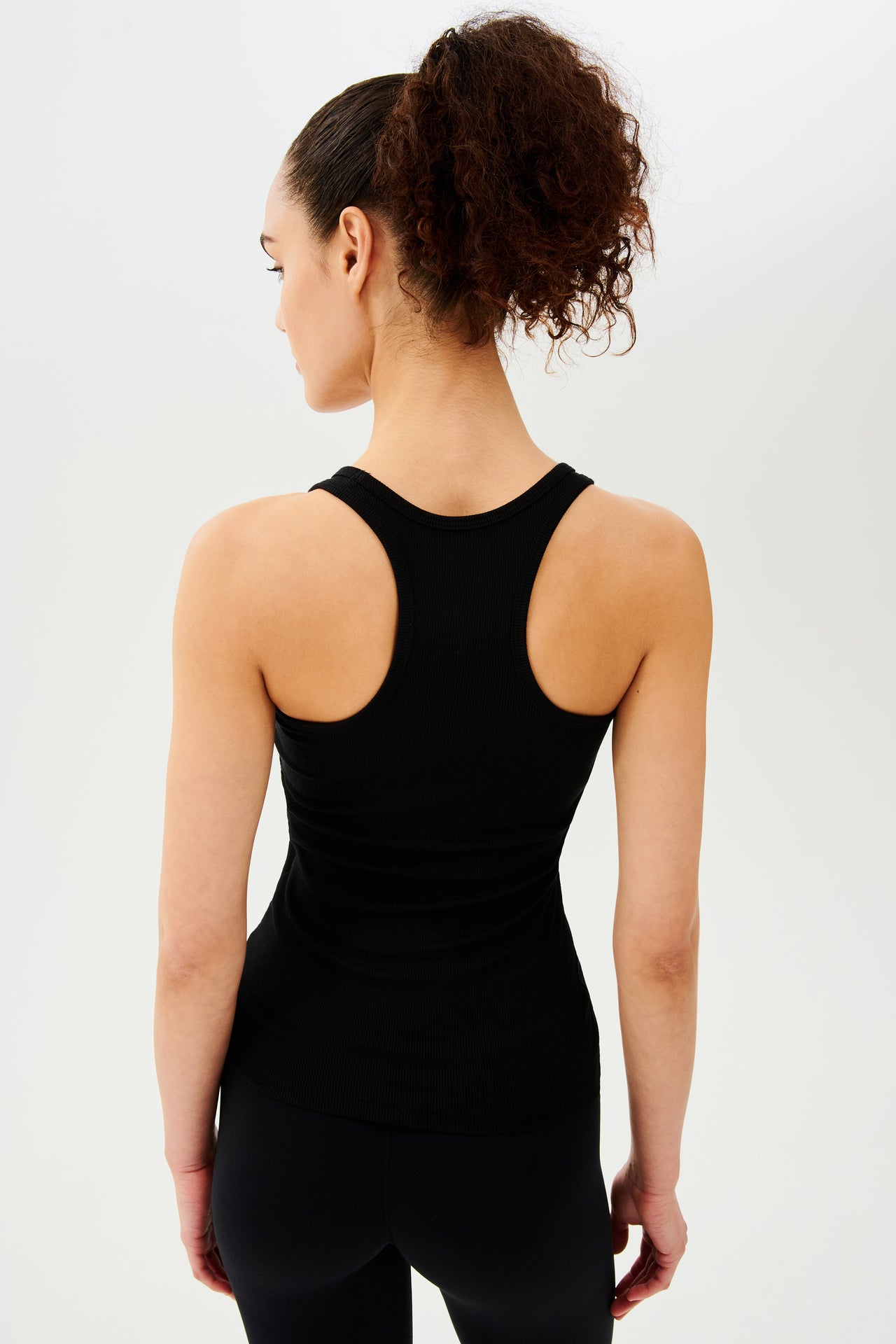 Back view of girl wearing a black tank top and black leggings