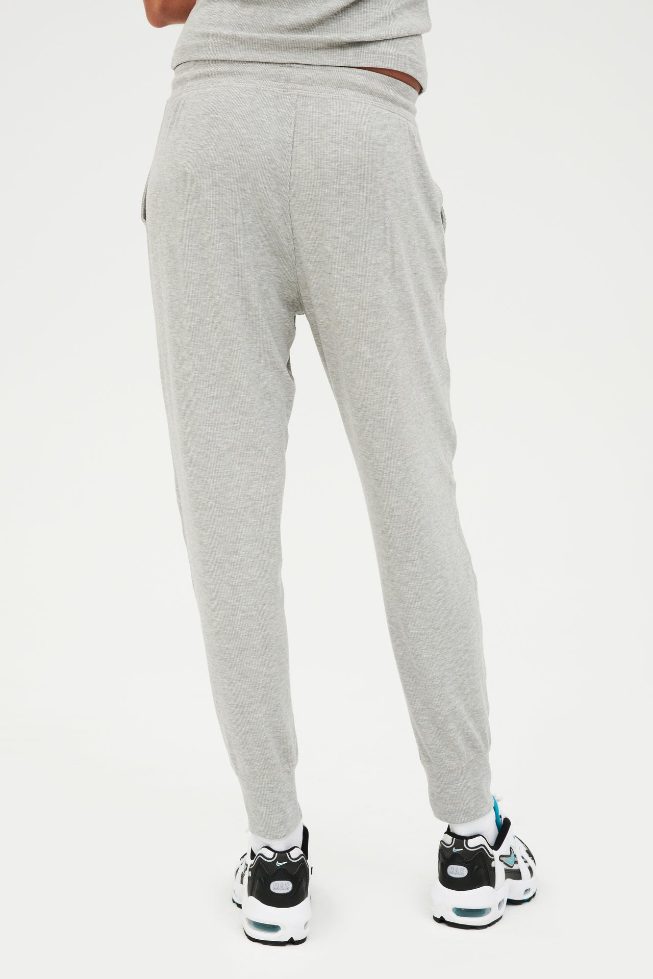 The back view of a woman wearing SPLITS59 Kiki Rib 7/8 Sweatpant in Heather Grey.